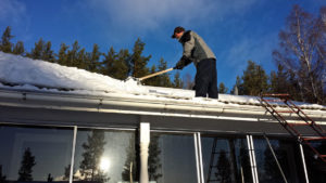  cleaning snow from a roof